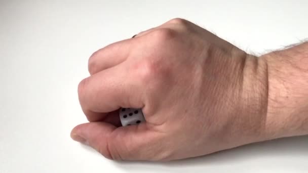 Game of dice. A few cubes lie on the table. The man takes them in his hand — Stock Video