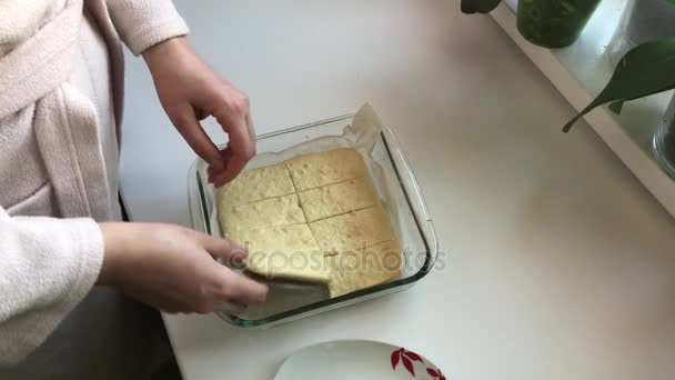 Voorbereiding van zelfgemaakte taarten. De vrouw verdeelt de gebakken taart in delen. — Stockvideo