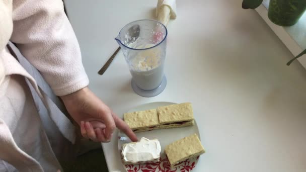 Zubereitung von hausgemachtem Kuchen. Eine Frau schmiert die Torten mit Sahne. — Stockvideo