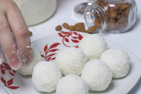 Příprava Raffaello sladkosti doma. Hotové cukroví leží na talíři. — Stock fotografie