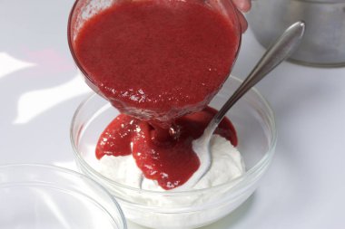 Süzme peynir ve çilek cheesecake. Pişirme işlemi. Çilek püresi ve süzme peynir karıştırma.