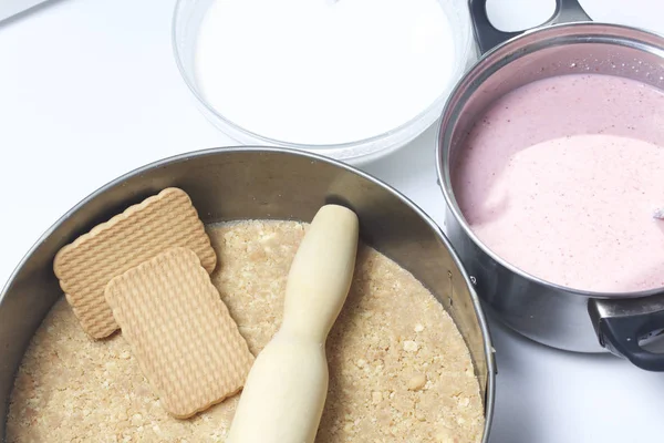 Torta di formaggio di ricotta e fragole. Processo di cottura. La base del biscotto e gli strati con aggiunta di gelatina sono sul tavolo . — Foto Stock