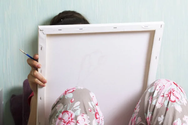 Art. Tekening van getallen. Een vrouw schildert een doek van katoen. Maakt gebruik van penselen, verven en water genummerd in een glas. — Stockfoto