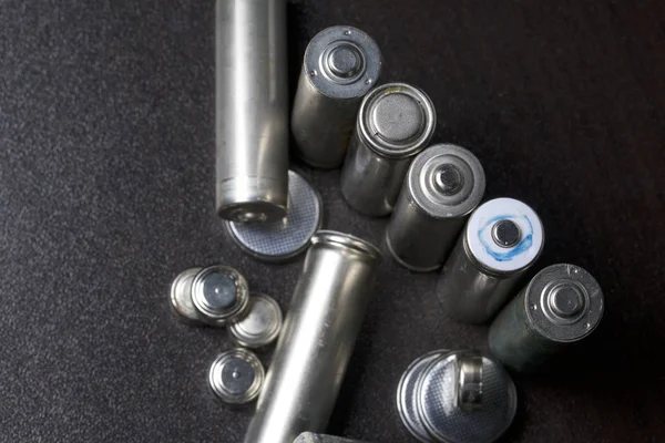 Batterien und grüne Sprossen. Recycling und Entsorgung von Batterien. Sorge um die Ökologie. — Stockfoto