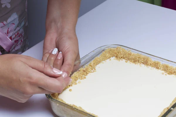 여자는 비스킷을 작성을 추가합니다. 블루베리와 치즈 하 케 섬세 한 잌 재료: 레몬 쿠키와 테이블에 서 서. — 스톡 사진