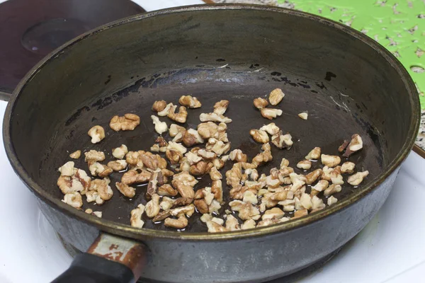 Memanggang kenari dalam wajan. Untuk memasak ayam dengan wortel dan kacang kenari . — Stok Foto