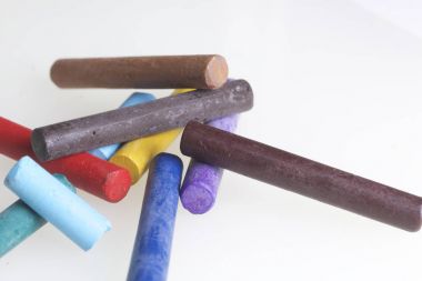 Farklı renklerde boya kalemi pastel. Bir kutu içinde onların yerleri, yalan. Beyaz bir arka plan üzerinde. Kaotik bir düzen içinde.