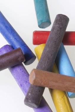 Farklı renklerde boya kalemi pastel. Bir kutu içinde onların yerleri, yalan. Beyaz bir arka plan üzerinde. Kaotik bir düzen içinde.