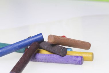 Farklı renklerde boya kalemi pastel. Bir kutu içinde onların yerleri, yalan. Beyaz bir arka plan üzerinde. Kaotik bir düzen içinde.