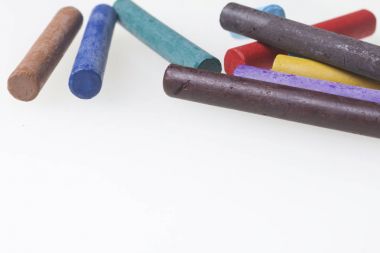 Farklı renklerde boya kalemi pastel. Bir kutu içinde onların yerleri, yalan. Beyaz bir arka plan üzerinde. Kaotik bir düzen içinde.