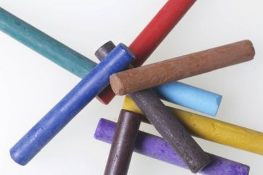 Farklı renklerde boya kalemi pastel. Bir kutu içinde onların yerleri, yalan. Beyaz bir arka plan üzerinde. Kaotik bir düzen içinde.