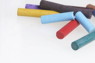 Farklı renklerde boya kalemi pastel. Bir kutu içinde onların yerleri, yalan. Beyaz bir arka plan üzerinde. Kaotik bir düzen içinde.