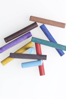 Farklı renklerde boya kalemi pastel. Bir kutu içinde onların yerleri, yalan. Beyaz bir arka plan üzerinde. Kaotik bir düzen içinde.