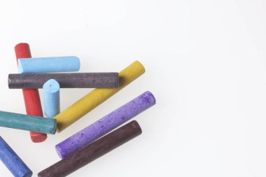 Farklı renklerde boya kalemi pastel. Bir kutu içinde onların yerleri, yalan. Beyaz bir arka plan üzerinde. Kaotik bir düzen içinde.