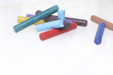 Farklı renklerde boya kalemi pastel. Bir kutu içinde onların yerleri, yalan. Beyaz bir arka plan üzerinde. Kaotik bir düzen içinde.