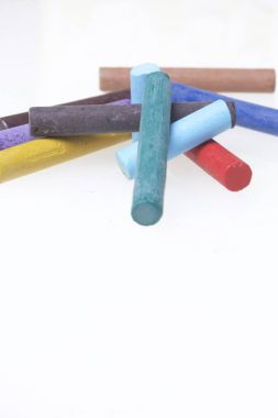 Farklı renklerde boya kalemi pastel. Bir kutu içinde onların yerleri, yalan. Beyaz bir arka plan üzerinde. Kaotik bir düzen içinde.