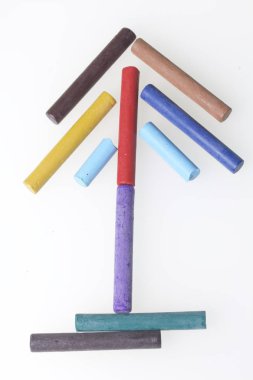 Farklı renklerde boya kalemi pastel. Bir kutu içinde onların yerleri, yalan. Bir ok şeklinde. Beyaz bir arka plan üzerinde. Karede çapraz olarak.