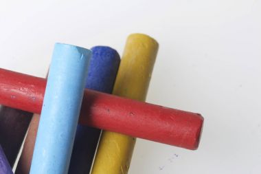 Farklı renklerde boya kalemi pastel. Bir kutu içinde onların yerleri, yalan. Beyaz bir arka plan üzerinde. Kaotik bir düzen içinde.