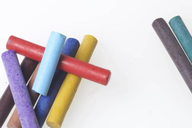 Farklı renklerde boya kalemi pastel. Bir kutu içinde onların yerleri, yalan. Beyaz bir arka plan üzerinde. Kaotik bir düzen içinde.