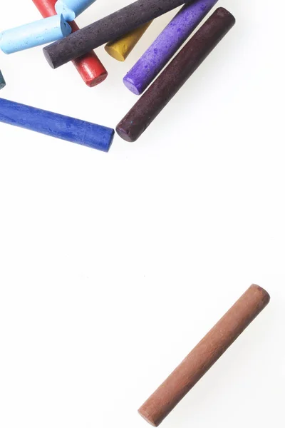 Crayons pastels in different colors. Lying in a box in their places. On a white background. In a chaotic order. — Stock Photo, Image