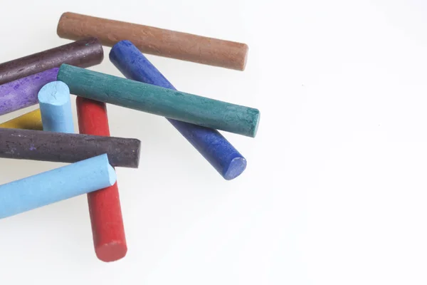 Crayones pasteles en diferentes colores. Acostados en una caja en sus lugares. Sobre un fondo blanco. En un orden caótico . — Foto de Stock