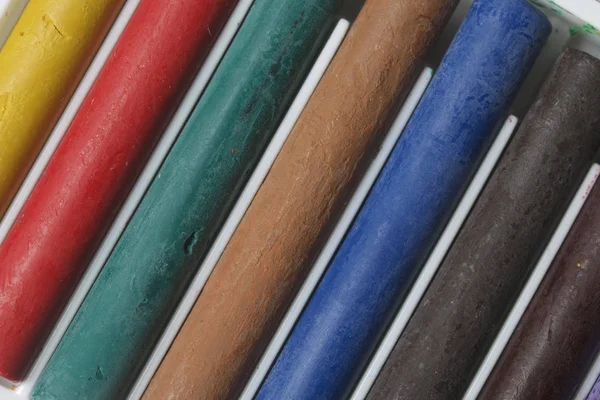 Ceruzák, kréták, különböző színekben. Feküdt egy doboz a helyükre. Fehér alapon. Átlósan a keret. — Stock Fotó