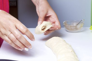 Rulo tarçın hazırlanması. Kadın iş parçası rulo ayrı rulo içine içine keser.