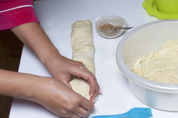Przygotowanie bułki cynamon. Kobieta wyłącza ciasta z nadzieniem z cynamonem i cukrem. — Zdjęcie stockowe
