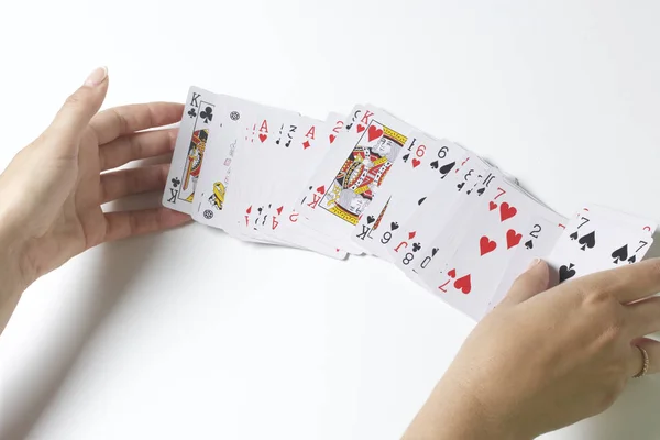 Jogo de cartas. Uma mulher está a baralhar um baralho de cartas. Em um fundo branco . — Fotografia de Stock