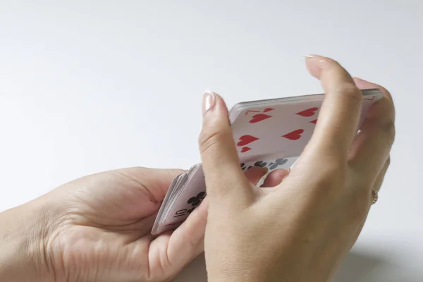 Juego de cartas. Una mujer está barajando una baraja de cartas. Sobre un fondo blanco . —  Fotos de Stock