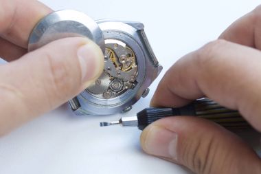 Watch atölye. Eski saatleri tamir. Saat, ana yapar onarır, tornavida, görünür bir mekanizmadır. Beyaz bir arka plan üzerinde.