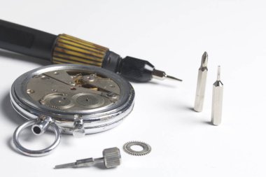 Watch atölye. Eski saatleri tamir. Saat, ana yapar onarır, tornavida, görünür bir mekanizmadır. Beyaz bir arka plan üzerinde.