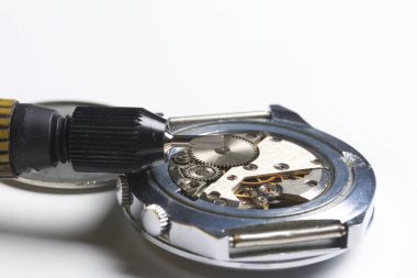 Watch atölye. Eski saatleri tamir. Saat, ana yapar onarır, tornavida, görünür bir mekanizmadır. Beyaz bir arka plan üzerinde.