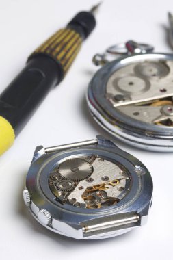 Watch atölye. Eski saatleri tamir. Saat, ana yapar onarır, tornavida, görünür bir mekanizmadır. Beyaz bir arka plan üzerinde.