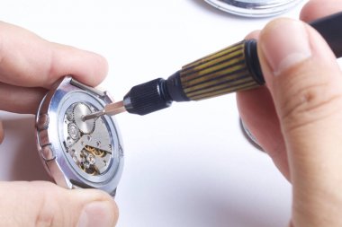 Watch atölye. Eski saatleri tamir. Saat, ana yapar onarır, tornavida, görünür bir mekanizmadır. Beyaz bir arka plan üzerinde.