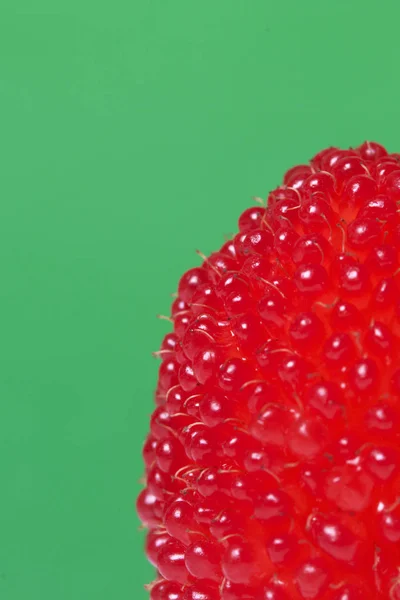 Большие красные ягоды похожи на малину. На зеленом фоне . — стоковое фото