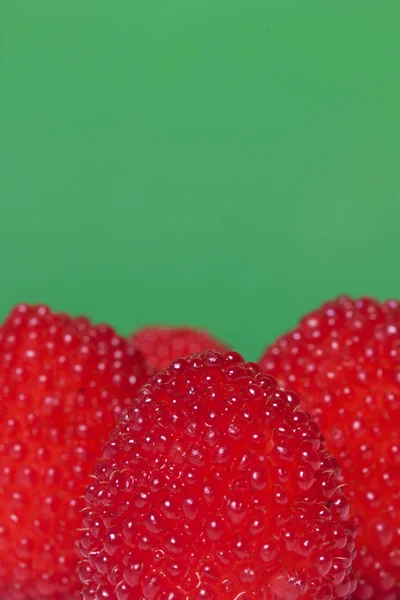 Große rote Beeren ähneln Himbeeren. auf grünem Hintergrund. — Stockfoto