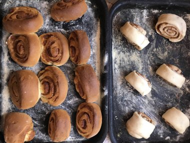 Evde tarçın ile buns hazırlanması. Tablo iki fırın yaprak vardır. Bir hazır buns, ham ile diğer ile.