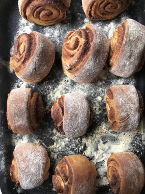 Evde tarçın ile buns hazırlanması. Hazır kırmızı buns bir tepsi üzerinde yalan.