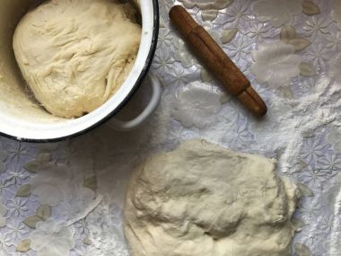 Evde tarçın ile buns hazırlanması. Tepsiyi un serpilir, hamur ve ahşap bir haddeleme pin masaya yalan.