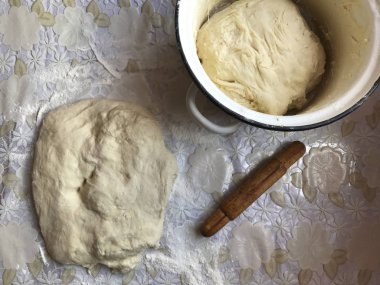 Evde tarçın ile buns hazırlanması. Tepsiyi un serpilir, hamur ve ahşap bir haddeleme pin masaya yalan.