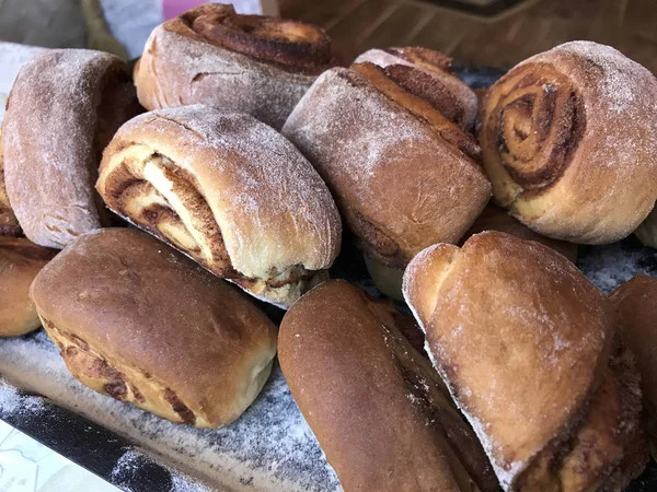 Evde tarçın ile buns hazırlanması. Hazır kırmızı buns bir tepsi üzerinde yalan.