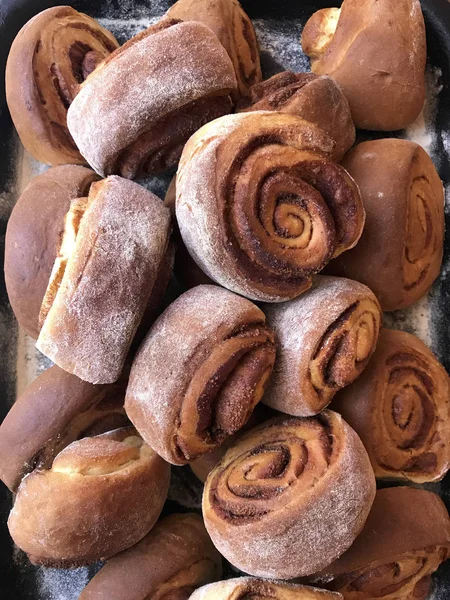 Zubereitung von Semmeln mit Zimt zu Hause. Fertige rohe Brötchen liegen auf einem Tablett. — Stockfoto