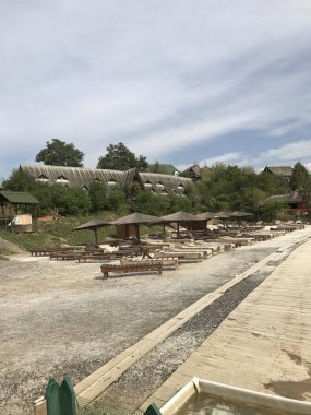 Bütçe tatil. Tuzlu su ile havuz kıyısında şezlong ve şemsiye ahşap ve saman ile yapılır.