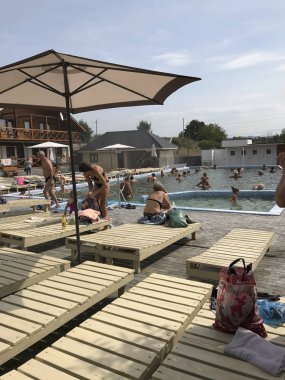 Solotvino, Transcarpathia, Ukrayna 9 Ağustos 2017; Küçük bir özel tatil tatil. İnsanlar havuzun madenden ve güneş altında ahşap şezlong üzerinde tuzlu su ile rahatlayın.