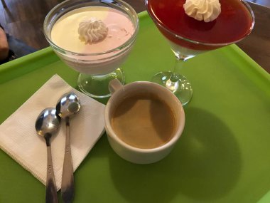 jöle, tatlılar ve kahve fincanı yeşil tepsi vardır. Kız onay hizmeti için değerlendirmeleri