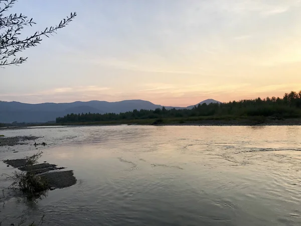 Günbatımı dağlık. Yumuşak yapraklara ufuktaki dağlar aydınlatmak. Ufuk Kurtlar Vadisi bir dağ nehir akar..