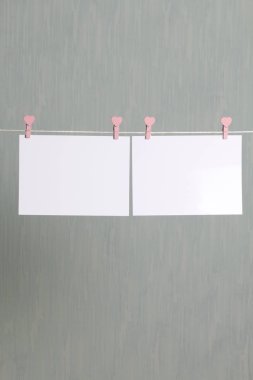 Fotoğrafik baskılar sonra gelişmekte olan bir kablosunun üzerine ve kuru sıkı. İçerik eklemek için bir yer vardır. Giyim mandal farklı pozisyonlarda kablosuyla bağlı. Bir gri-yeşil arka plan üzerinde.