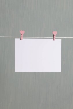 Fotoğrafik baskılar sonra gelişmekte olan bir kablosunun üzerine ve kuru sıkı. İçerik eklemek için bir yer vardır. Giyim mandal farklı pozisyonlarda kablosuyla bağlı. Bir gri-yeşil arka plan üzerinde.