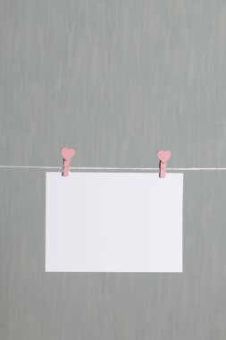 Fotoğrafik baskılar sonra gelişmekte olan bir kablosunun üzerine ve kuru sıkı. İçerik eklemek için bir yer vardır. Giyim mandal farklı pozisyonlarda kablosuyla bağlı. Bir gri-yeşil arka plan üzerinde.